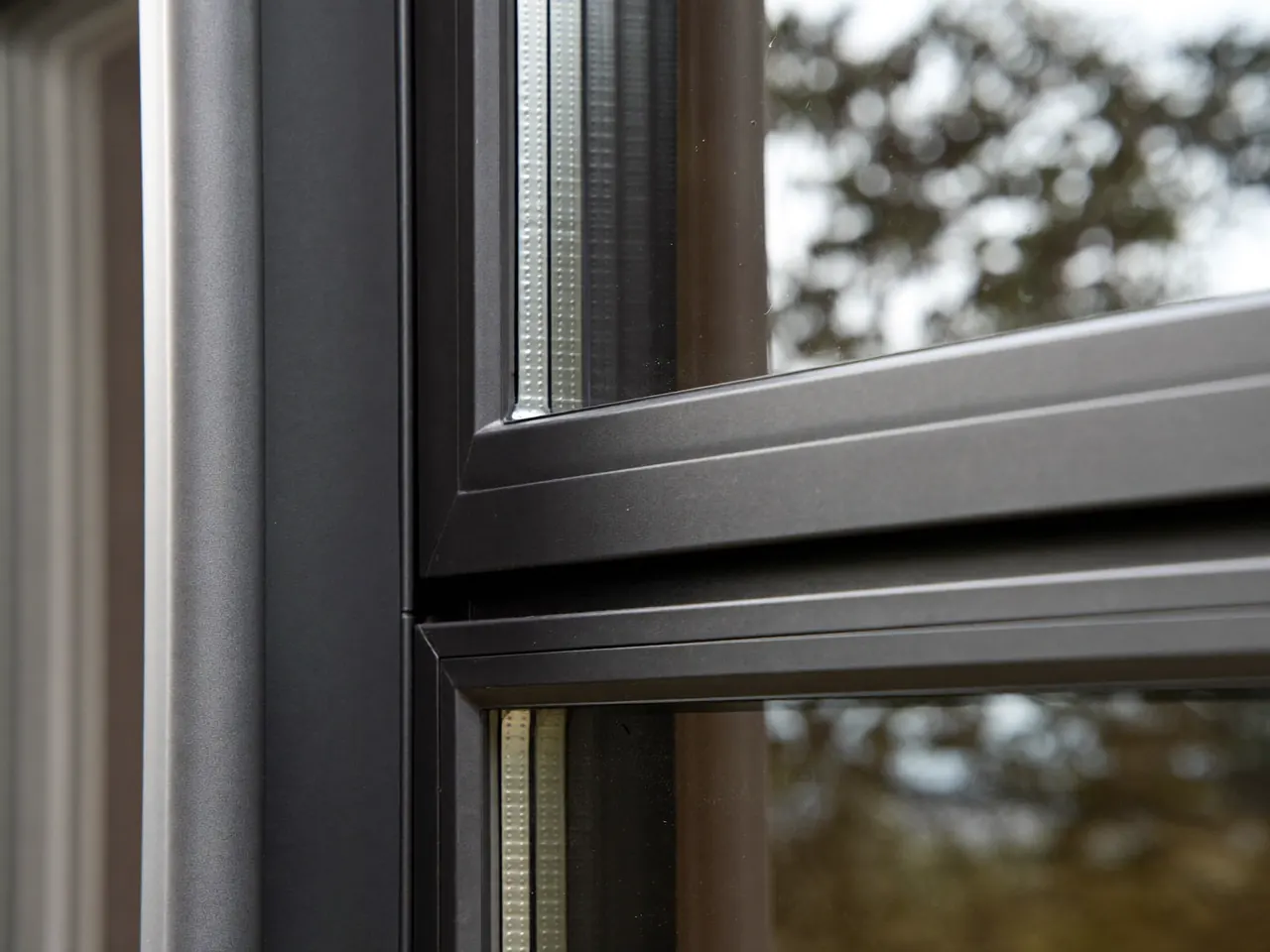 Detail of a slim window frame showing the handle and hinge fittings