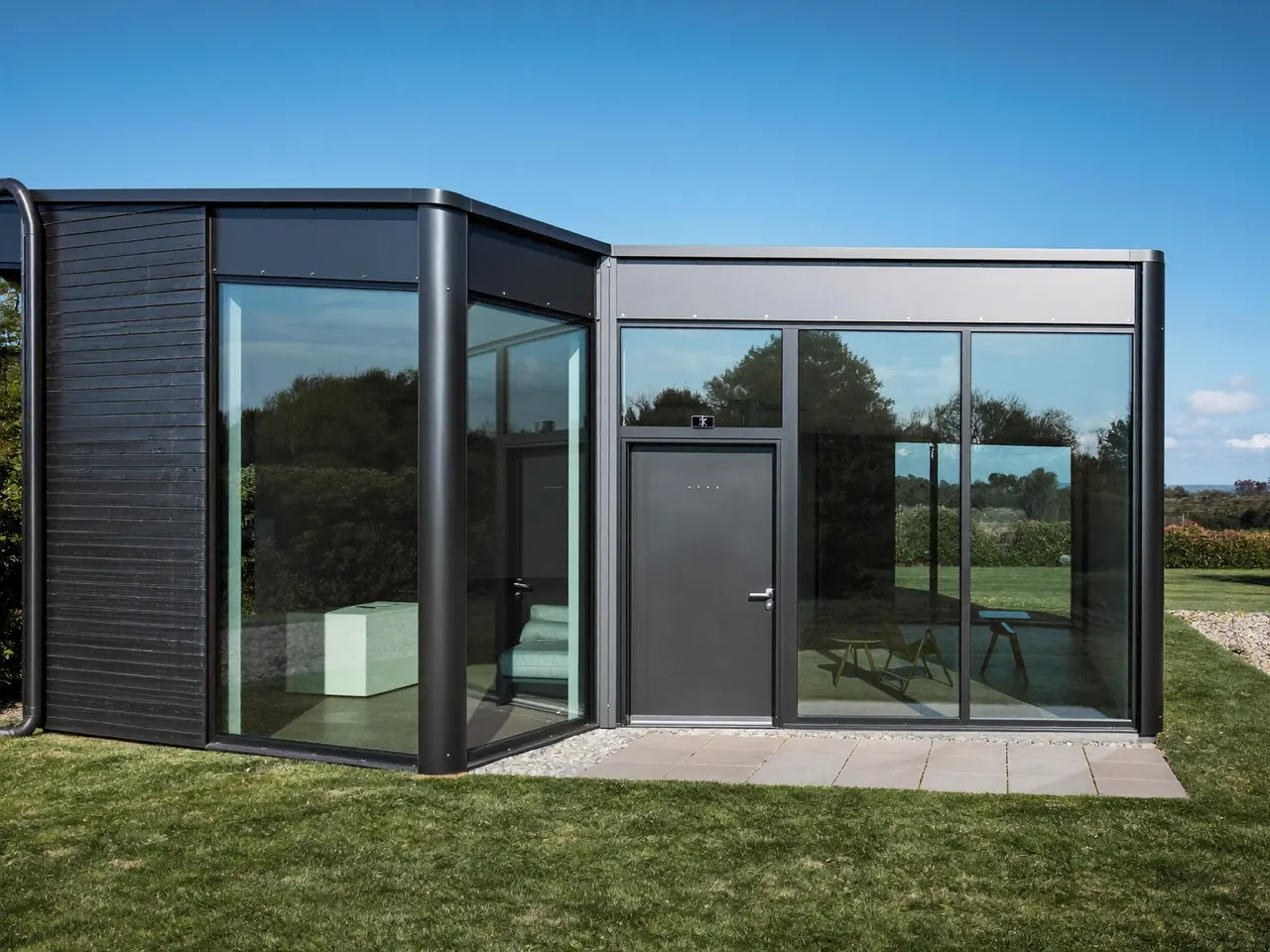 Anthracite aluminium windows framing a modern rendered extension