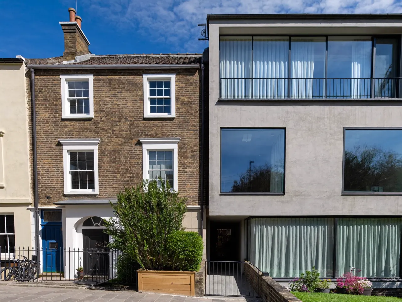 Windows on a period terrace beside a contemporary rendered home