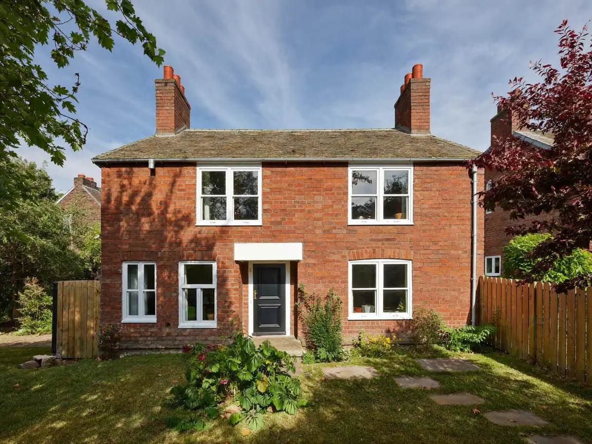White uPVC double glazing on a red-brick British semi-detached home